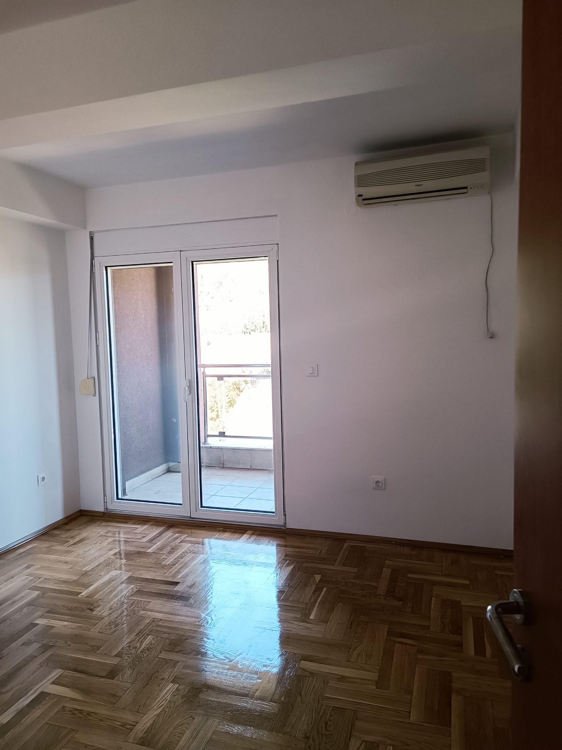 Nekretnina u Crnoj Gori - Prostorija sa drvenim podom i velikim prozorima prema terasi